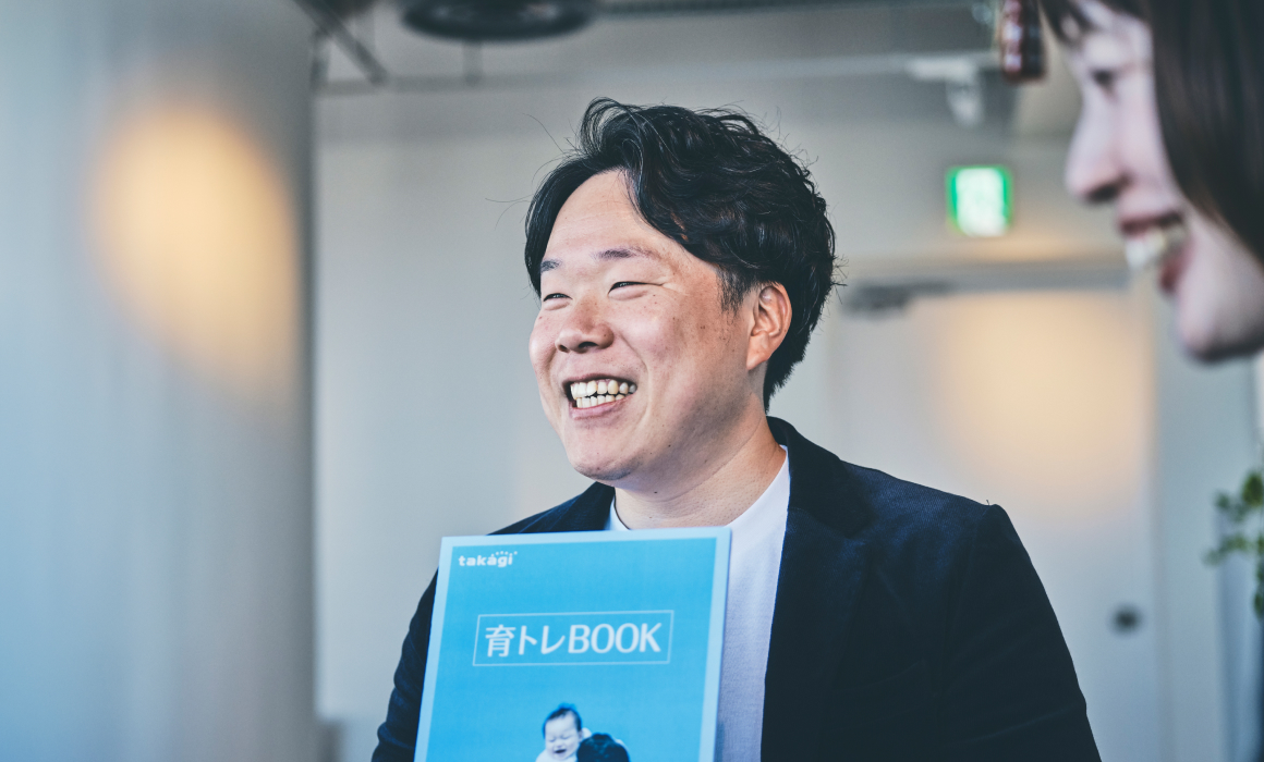 育トレBOOKを手にする社員　写真